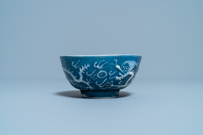 A Chinese white slip-decorated blue-ground 'dragon' bowl, Yu Tang Jia Qi mark, Wanli