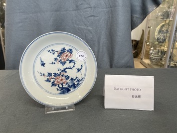 Een Chinees blauw-wit en koperrood bord met floraal decor, Kangxi