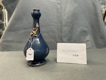 A Chinese monochrome blue garlic head vase with applied biscuit dragon, Jiajing
