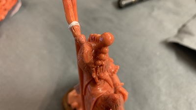 A Chinese carved red coral figure of a warrior holding a flag, 19/20th C.
