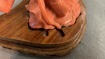 A Chinese carved red coral figure of a warrior holding a flag, 19/20th C.