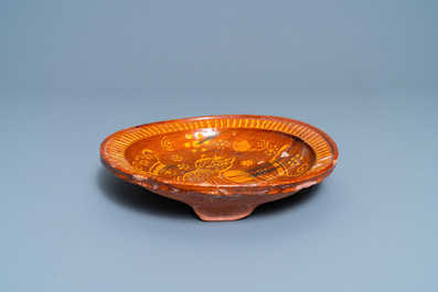 A Dutch slip-decorated pottery dish with an owl, dated 1585