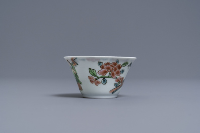 A Chinese famille rose 'tea scene' cup and saucer, Yongzheng/Qianlong