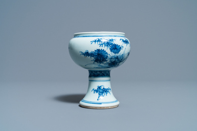 Een Chinese blauw-witte stem cup met floraal decor, Kangxi/Yongzheng