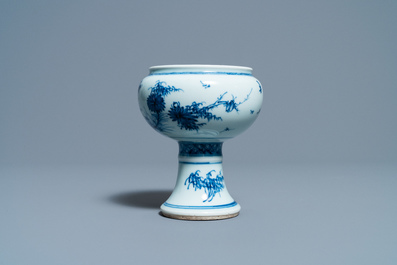 Een Chinese blauw-witte stem cup met floraal decor, Kangxi/Yongzheng