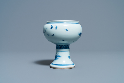Een Chinese blauw-witte stem cup met floraal decor, Kangxi/Yongzheng