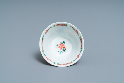 A Chinese famille rose 'tea scene' cup and saucer, Yongzheng/Qianlong