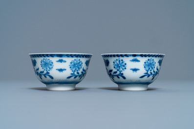 A pair of Chinese blue and white 'Caritas' cups and saucers, Kangxi/Yongzheng