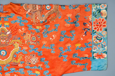 A Chinese embroidered silk red-ground 'dragon' robe, 19th C.