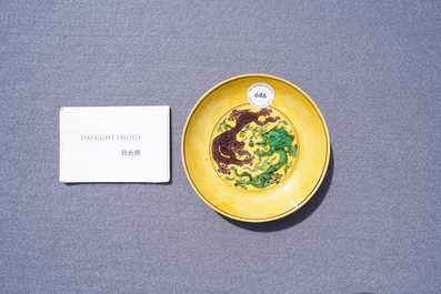 Une coupe en porcelaine de Chine &agrave; d&eacute;cor de dragons en vert et aubergine sur fond jaune, marque et &eacute;poque de Kangxi