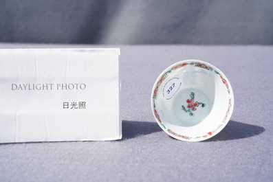 A Chinese famille rose 'tea scene' cup and saucer, Yongzheng/Qianlong