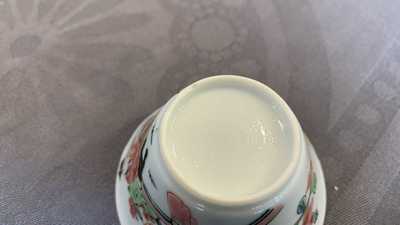 A Chinese famille rose 'tea scene' cup and saucer, Yongzheng/Qianlong