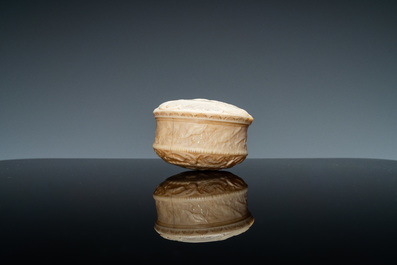 An ivory box and cover with a boy sitting by a water well, 18th C.