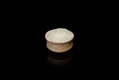 An ivory box and cover with a boy sitting by a water well, 18th C.