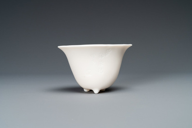A Chinese Dehua blanc de Chine tripod wine cup with inscription, Kangxi