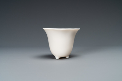 A Chinese Dehua blanc de Chine tripod wine cup with inscription, Kangxi
