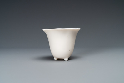 A Chinese Dehua blanc de Chine tripod wine cup with inscription, Kangxi