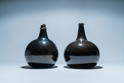 Two large dark green glass bottles with painted inscriptions, 17/18th C.