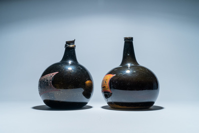 Two large dark green glass bottles with painted inscriptions, 17/18th C.