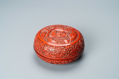 A Chinese round cinnabar lacquer box and cover with two scholars at a table, 18/19th C.