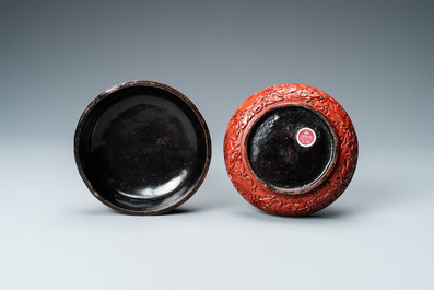 A Chinese round cinnabar lacquer box and cover with two scholars at a table, 18/19th C.