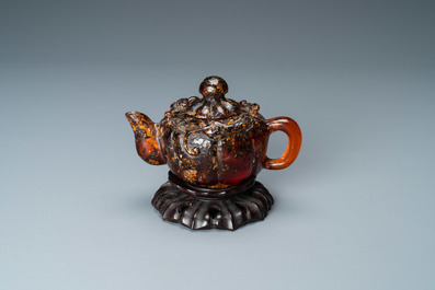 Une th&eacute;i&egrave;re couverte en ambre sculpt&eacute; sur socle en forme de lotus en bois sculpt&eacute;, 19&egrave;me