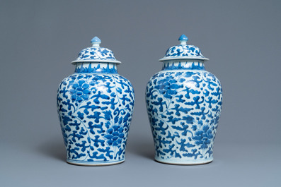 A pair of Chinese blue and white 'peony scroll' vases and covers, Kangxi