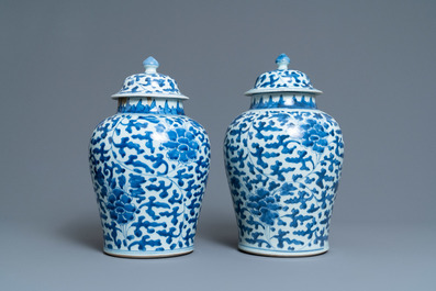 A pair of Chinese blue and white 'peony scroll' vases and covers, Kangxi