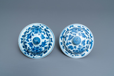 A pair of Chinese blue and white 'peony scroll' vases and covers, Kangxi