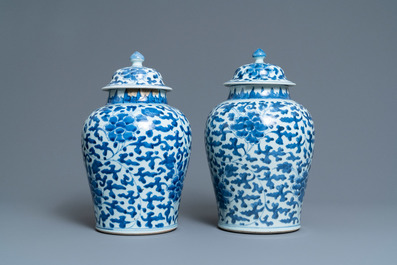 A pair of Chinese blue and white 'peony scroll' vases and covers, Kangxi