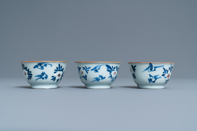 Three Chinese blue, white and copper-red cups and saucers, Kangxi