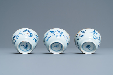 Three Chinese blue, white and copper-red cups and saucers, Kangxi