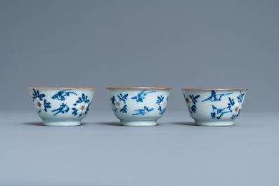 Three Chinese blue, white and copper-red cups and saucers, Kangxi