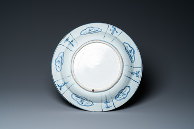 Un grand plat en porcelaine de Chine de type kraak &agrave; d&eacute;cor de figures dans un paysage, Wanli