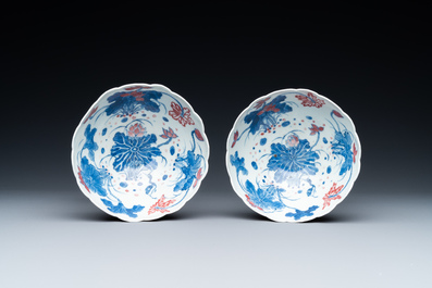 A pair of Chinese blue, white and copper-red 'lotus' bowls, Kangxi mark, 19th C.