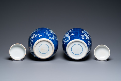 A pair of large Chinese blue and white 'prunus' jars and covers, 19th C.