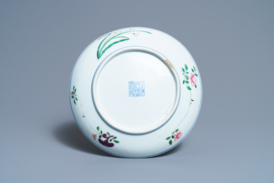 Un plat en porcelaine de Chine famille rose &agrave; d&eacute;cor d'un gar&ccedil;on, un coq, une poule et leurs poussins, marque minyao et &eacute;poque de Qianlong