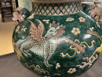 A pair of Chinese famille verte 'mythical animals' vases and covers, 19th C.