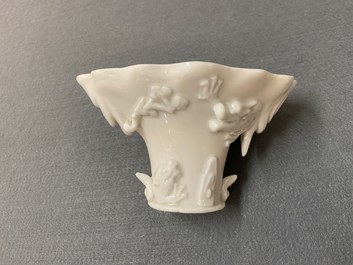 Een Chinese blanc de Chine libation cup en een koraalrode met vergulding, Kangxi en 19e eeuw