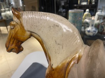 Un mod&egrave;le d'un cheval en terre cuite &agrave; gla&ccedil;ure ambre et beige, Chine, Tang