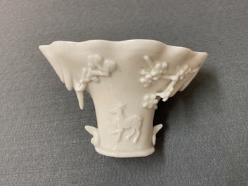 Een Chinese blanc de Chine libation cup en een koraalrode met vergulding, Kangxi en 19e eeuw