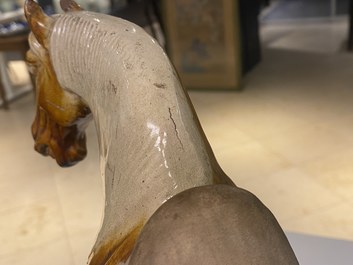 Un mod&egrave;le d'un cheval en terre cuite &agrave; gla&ccedil;ure ambre et beige, Chine, Tang