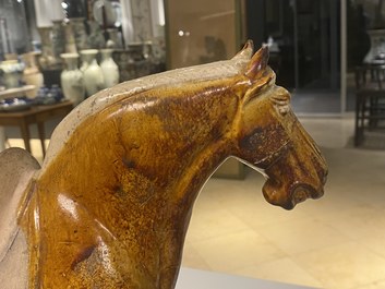 Un mod&egrave;le d'un cheval en terre cuite &agrave; gla&ccedil;ure ambre et beige, Chine, Tang