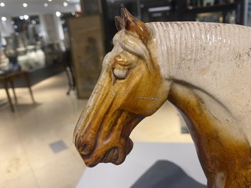 Un mod&egrave;le d'un cheval en terre cuite &agrave; gla&ccedil;ure ambre et beige, Chine, Tang