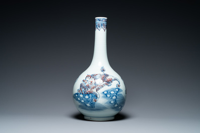A Chinese blue, white and copper-red bottle vase with Buddhist lions, 20th C.