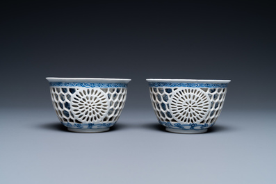 A pair of Chinese blue and white reticulated double-walled cups and saucers, Kangxi