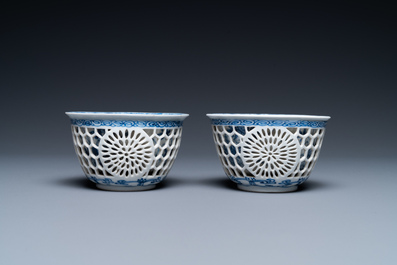 A pair of Chinese blue and white reticulated double-walled cups and saucers, Kangxi