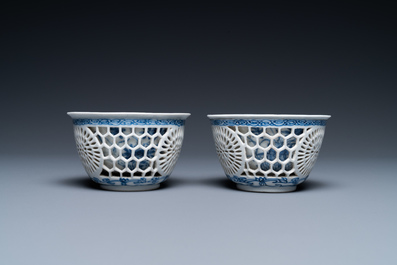 A pair of Chinese blue and white reticulated double-walled cups and saucers, Kangxi