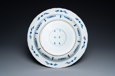 A Chinese blue and white dish with two ladies and two rabbits in a garden, Kangxi mark and of the period