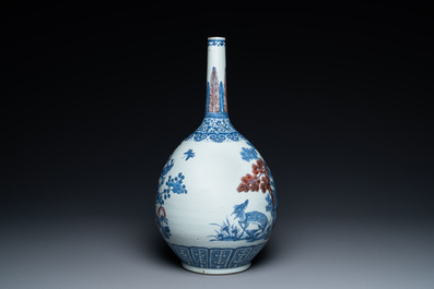 A Chinese blue, white and copper-red bottle vase with a deer and birds among blossoming branches, Daoguang